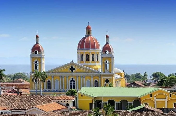 Granada's yellow cathedral above red-tiled roofs, with Lake Nicaragua behind